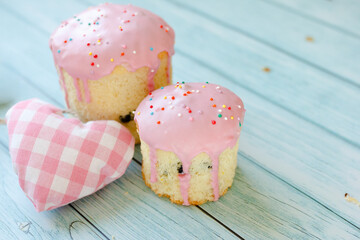 Sweet pink cake dessert and pink heart on blue wooden background. Valentines day