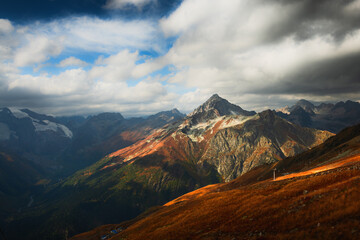 Mountain range with clouds at sunset in Dombay, North Caucasus, Russia. Beautiful autumn landscape.