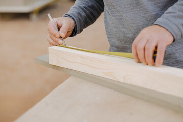 Closeup shot of a carpenter marking some dimensions in wood