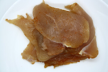 Chicken fillet pieces on a white plate.