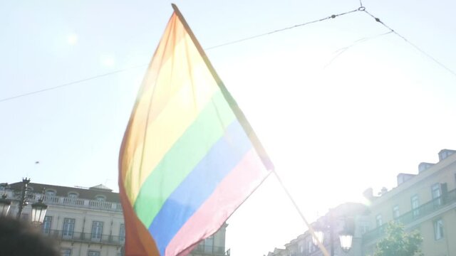 holding big rainbow flag in parade slow motion