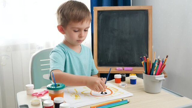 Little boy drawing picture in school classroom. Creative child doing art painting. Education at home during lockdown