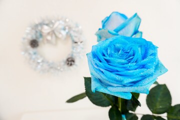 二輪の青いバラと銀色のリース飾り