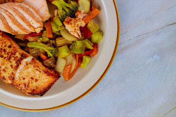 Grilled salmon garnished with asian vegetables. Top view.