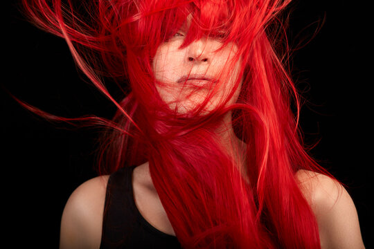 Hair color concept. Young woman with shiny and long flying red hair