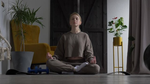 girl doing meditation on the rug at home next to the dog