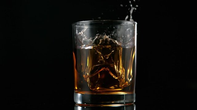 Camera Follows Ice Cube falling into Glass of Whisky in Super Slow Motion. Shot with High Speed Cinema Camera, 1000fps.