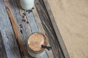 Top down view of fresh homemade Dalgona coffee on a wooden tray.