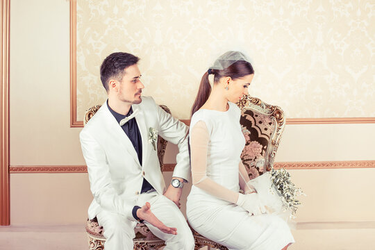 Angry Young Bride And Groom Upset On Each Others Sitting In Armchairs