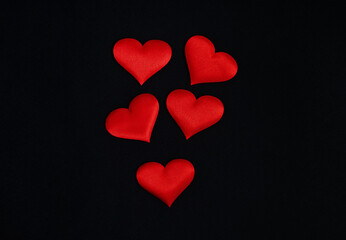 Top view of red hearts spread on a black background. Border, copy space, celebration, holiday.