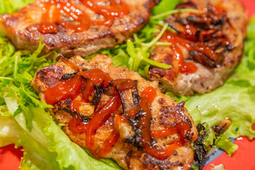 Appetizing juicy piece of well-done meat and fresh green lettuce leaves