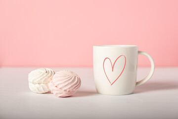 Mug with earring and sweets on a pink background. Valentine's Day concept. Banner