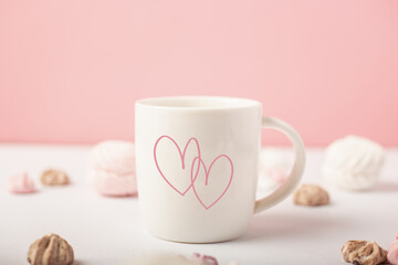Mug with hearts and sweets on a pink background. Valentine's Day concept. Banner