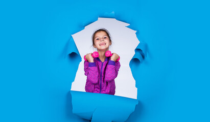 Be strong. beautiful teen girl with barbell. kid fashion style. female sporty lifestyle. happy childhood. cute child on blue background. use dumbbells tool while workout