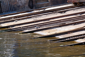 Part of a boat ramp made of wood and metal on the water. Dock of a shipyard for small boats in need of repair