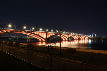 Illuminated bridge across the river in winter