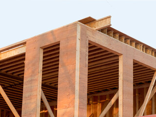 corner walls of a house under construction showing plywood sheathing and engineered wood floor joists for a second story