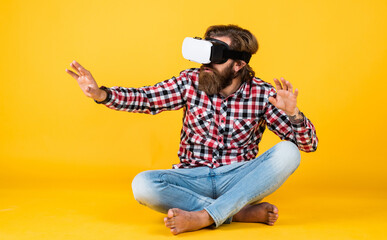 brutal bearded man wear checkered shirt having lush beard and moustache in vr glasses, virtual world