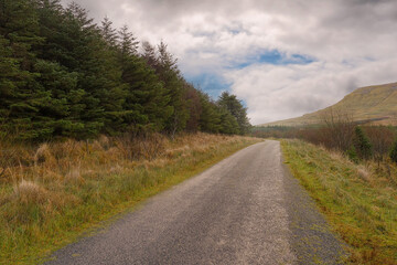 Small narrow road by a forest by a mountains. Gleniff horseshoe drive, county Sligo, Ireland, Cloudy sky, Travel concept. Nature landscape.