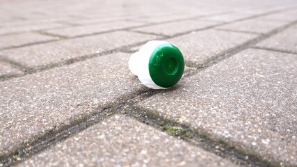 Obraz premium Champagne Sparkling Wine Plastic Cork on Brick Sidewalk After New Year's Party