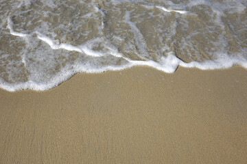 Fototapeta na wymiar Sea wave on the beach, selective focus with copy space