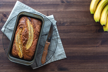 Top down view of a banana bread loaf fresh out of the oven on a cooking rack.