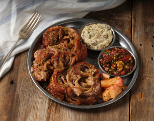 kokorec with mezes with a fork on a metal plate on wooden background
