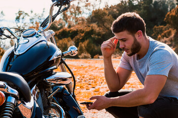 Crouching biker worried about a motorcycle breakdown © Victor Mulero