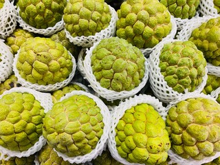 Close-up photo of Sugar Apple in market. Group of fruits background. Sweetsop or Custard Apple.