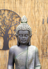 Closeup of statue of buddha with bamboo background