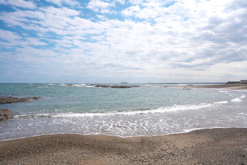 静かな波の日の秋の日本の海岸