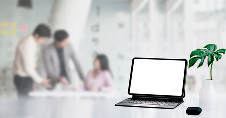 Mockup blank screen tablet with magic keyboard on white table in modern room.