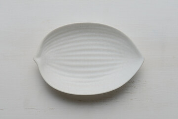 白く塗られた板の上に置かれた白い葉っぱ型の皿