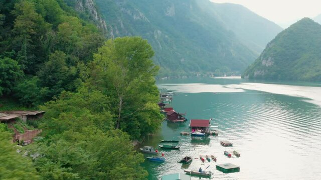 Floating Houses Of Perucac Lake On The Drina River, Western Serbia, Surrounded By A Valley, Narrow Canyon And Forest - aerial drone shot