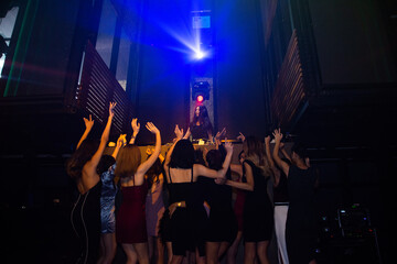 Fototapeta premium Group people women dancing in night party with DJ EDM Music