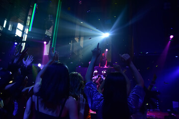 Fototapeta na wymiar Group people women dancing in night party with DJ EDM Music