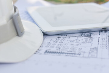 Hard hat safety on blueprint on site construction selective focus