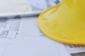 Hard hat safety on blueprint on site construction selective focus