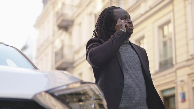 African american black man having phone conversation near hs car. Successful man on phone call. High quality 4k footage