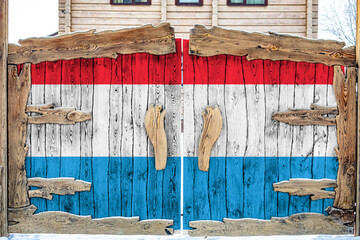 Fototapeta na wymiar Close-up of the national flag of Luxembourg on a wooden gate at the entrance to the closed territory. The concept of storage of goods, entry to a closed area.