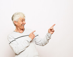 Lifestyle, emotion and old people concept. Happy senior man show something over white background
