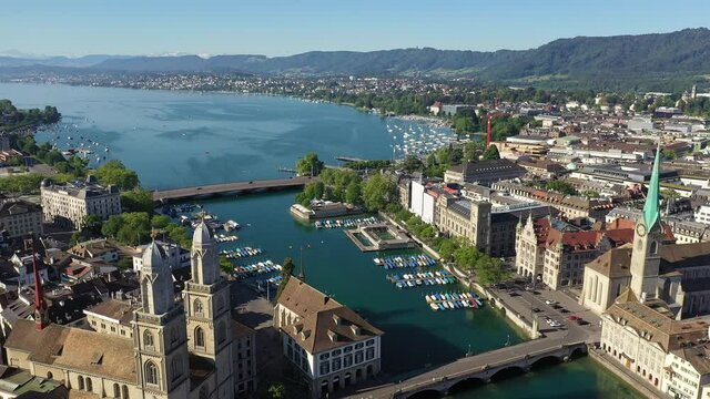 Aerial drone footage of the famous Zurich old town along the Limmat river and lake Zurich on a sunny summer day in Switzerland largest city. 