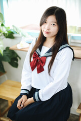 Japanese school girl sitting in local coffee shop