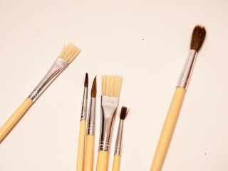 Set of painting brush with wooden handle, laid on a white isolated background