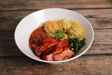 Shrimp dumpling with roasted pork with local thai tom yum spicy sauce on wood background