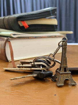 miniature Eiffel tower key chain and some keys and books