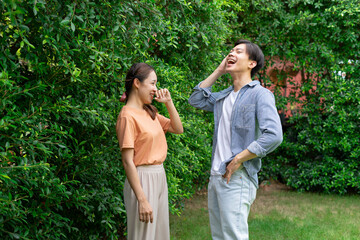Obraz premium Young asian couple talking to each other at yard.