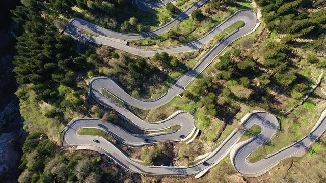Aerial footage of cars driving on the Maloja pass road in the Canton Graub&uuml;nden in the alps in Switzerland. Shot with a drone with a downward and rotation motion.
