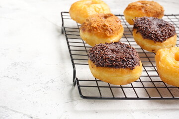 Top view of Donat or Donut or Doughnut as circle with hole sweet bread topped with caramel and biscuit crumbs, chocolate glazed with chocolate sprinkles. Selective focus, copy space,white  background
