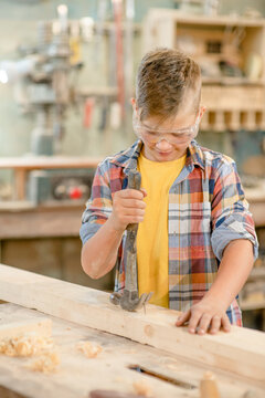 Young boy enjoys a carpentry hobby in the workshop